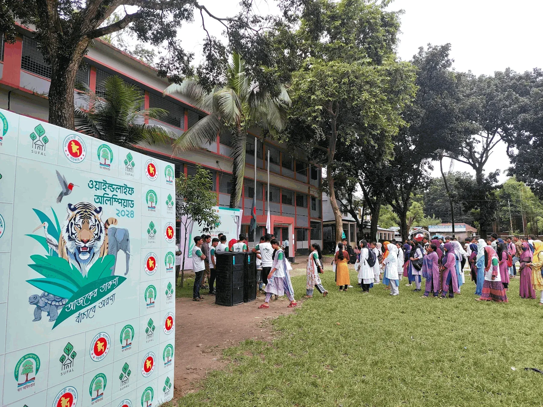 Students at a district round beside the olympiad backdrop